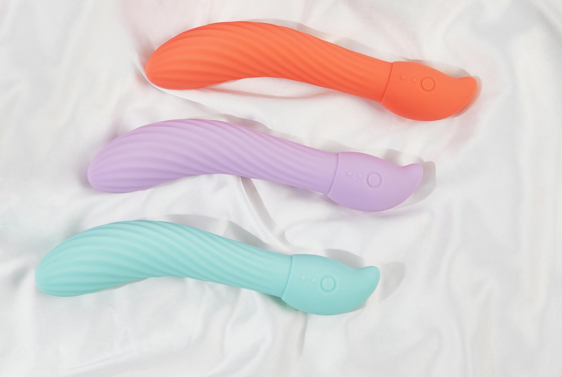 A blue silicone vibrator held gently in hand against a purple background, symbolizing intentional pleasure and recovery
