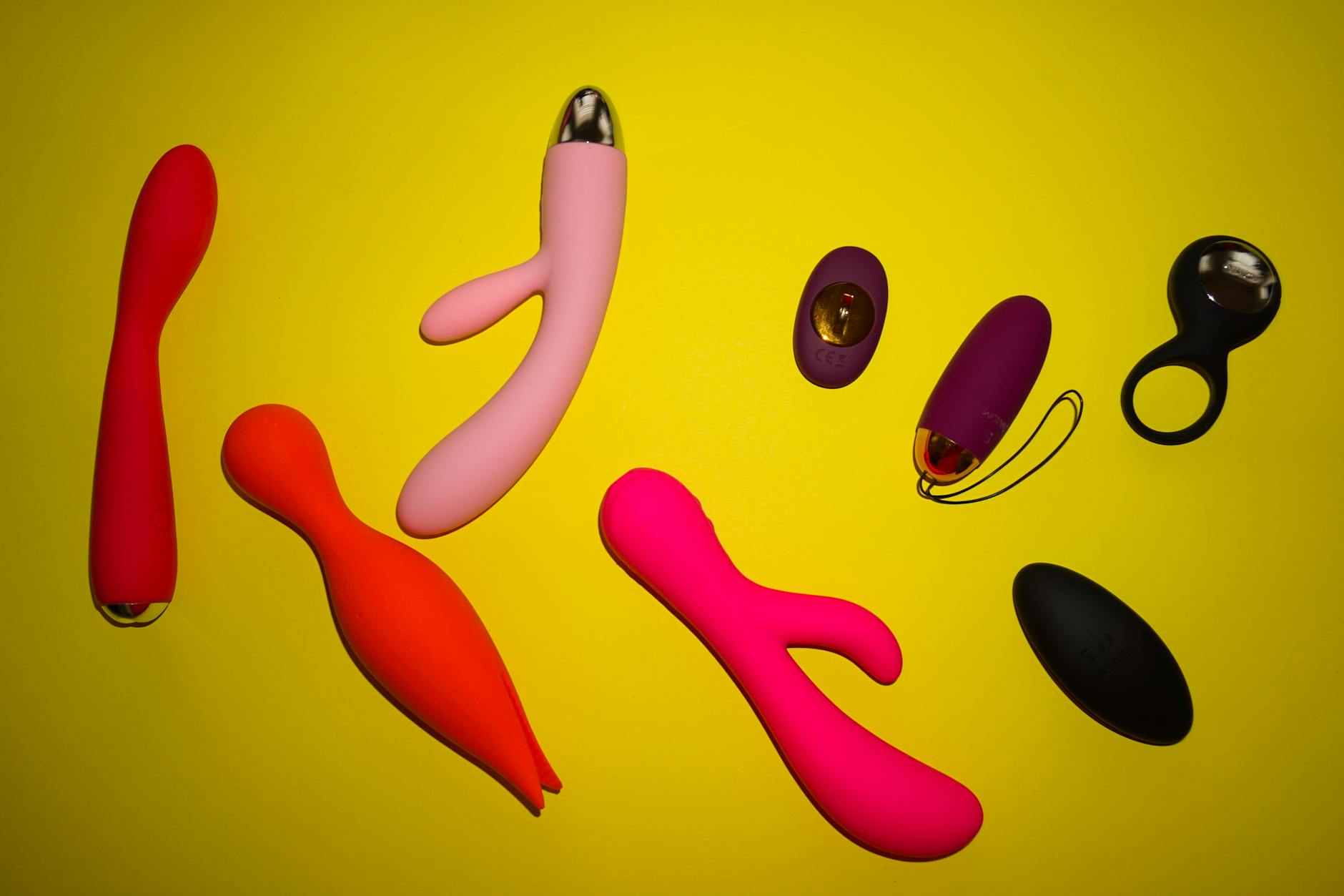 Woman holding blue and pink silicone vibrators in a thoughtful moment, representing the journey toward self-discovery