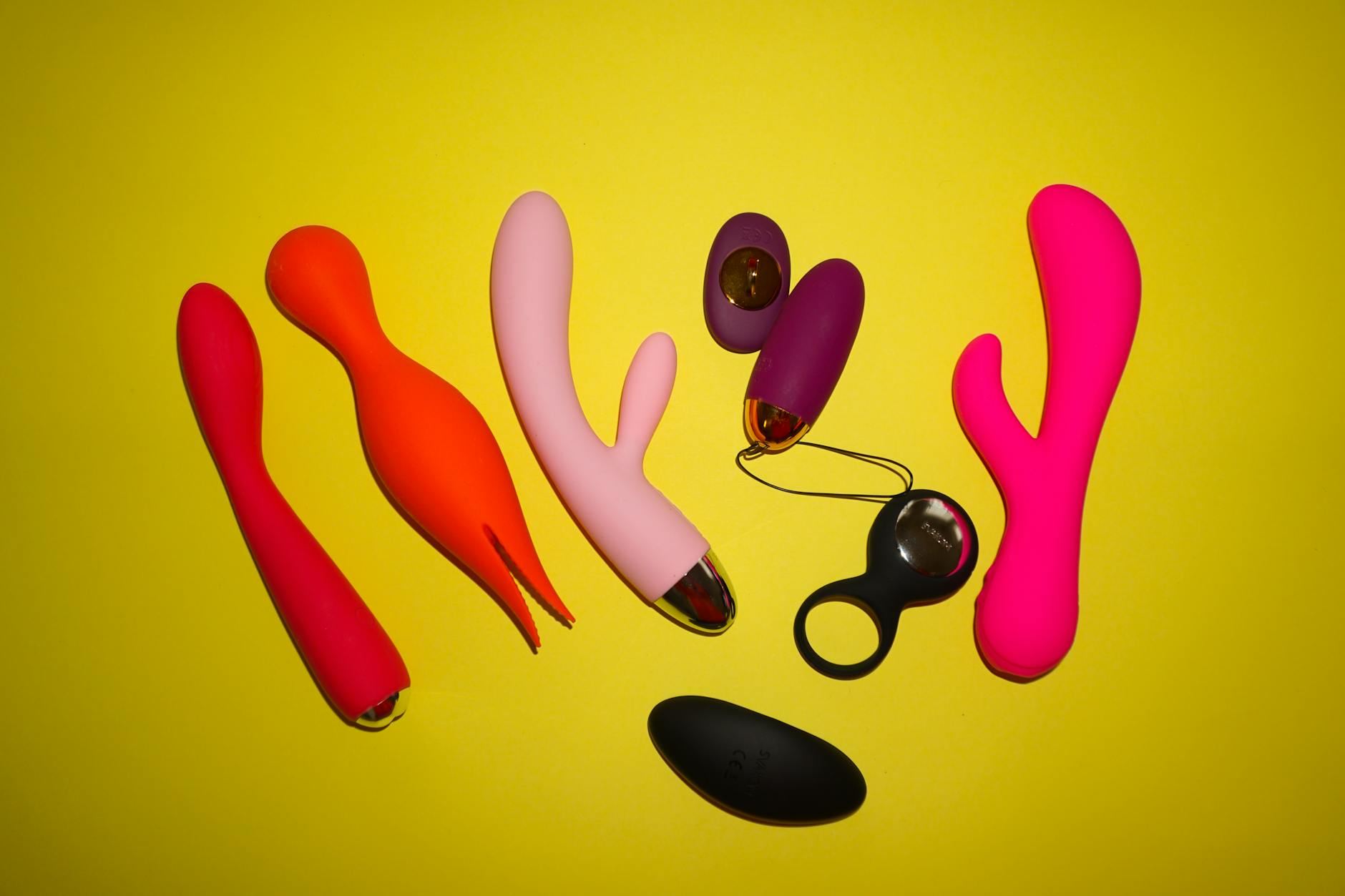 Colorful vibrators and lemon slices arranged on a bright surface, showing variety in design and intensity options